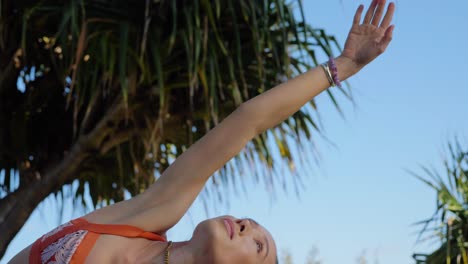 yogui haciendo tabla lateral en la rodilla con una pierna extendida en la espalda y el brazo extendido hacia el cielo - fortalece los brazos, el vientre y las piernas - yoga en la playa