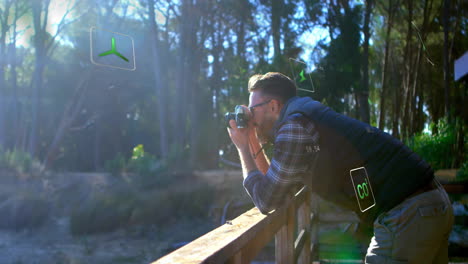 photographing nature, man surrounded by digital environmental animation in forest