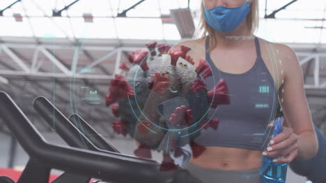 animación de la célula de covid 19 sobre una mujer con máscara facial limpiando el equipo en el gimnasio