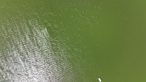 An-aerial-view-over-a-lake-in-Flushing-Meadow-Corona-Park-in-Queens,-NY-on-a-sunny-day