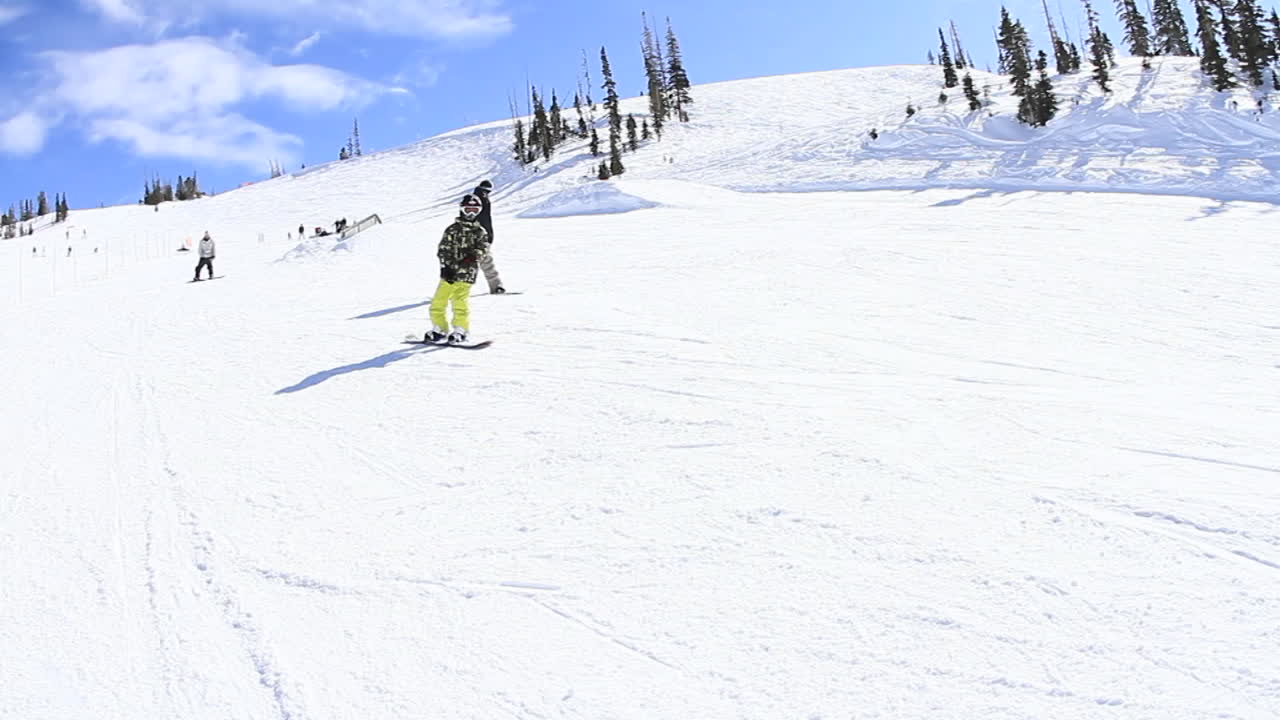 un joven snowboarder baja una colina