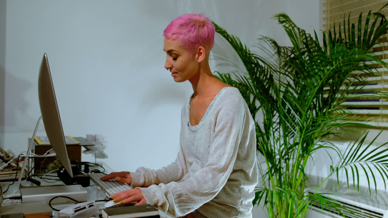 Pink hair woman working on computer 4k