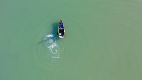 Aerial-top-down-forward-over-fisherman-in-Soco-River-mouth-with-fishing-criminal-method,-Dominican-Republic