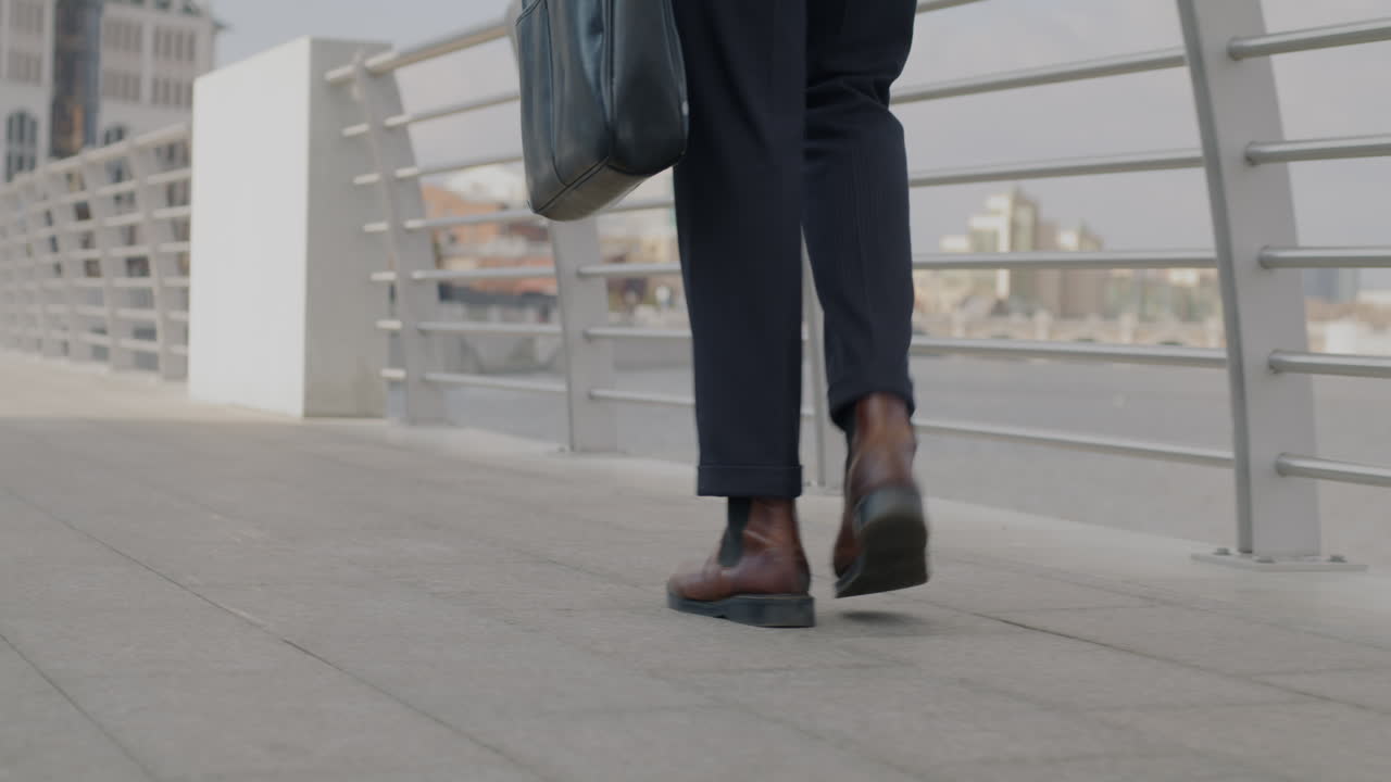 un hombre de negocios caminando por un puente.