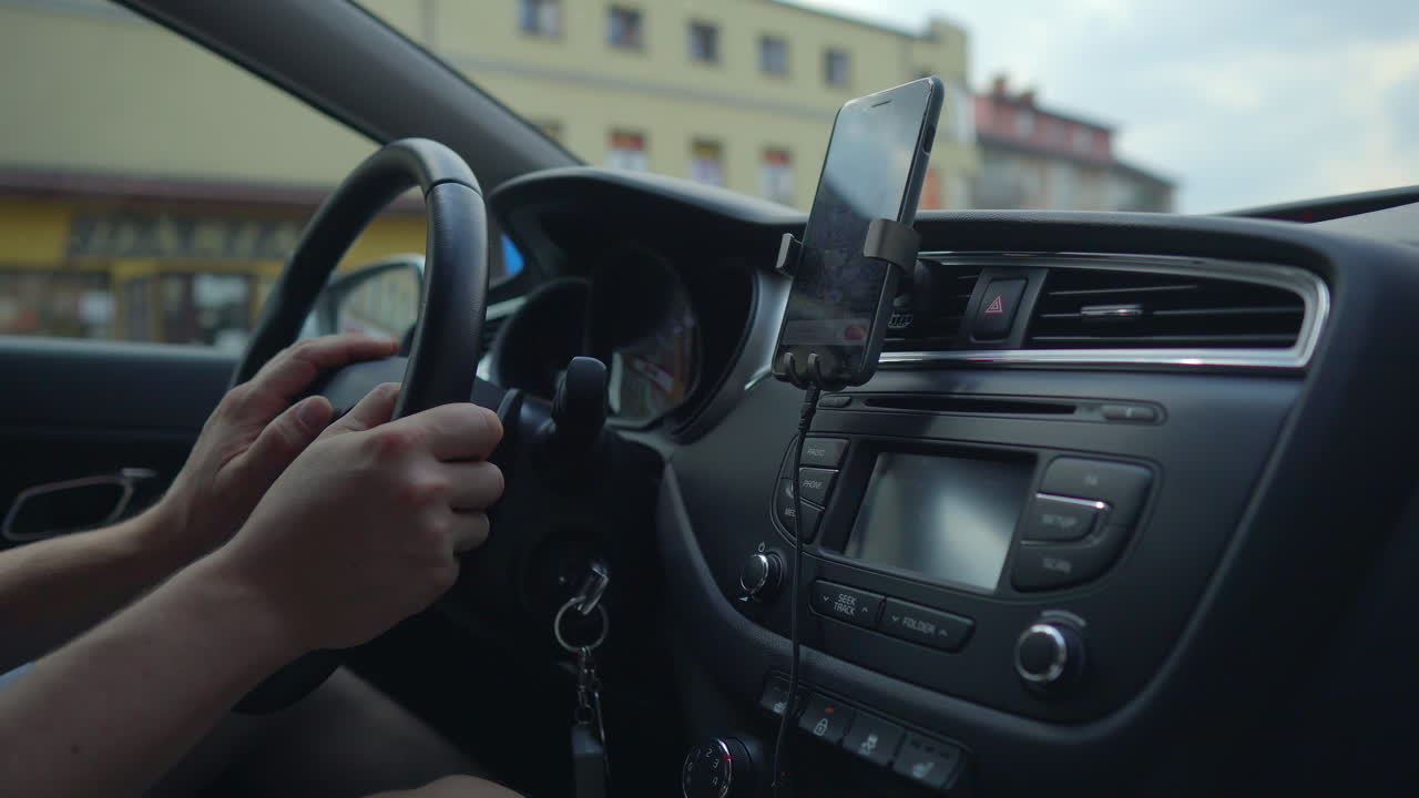 스마트폰으로 차를 운전하는 사람