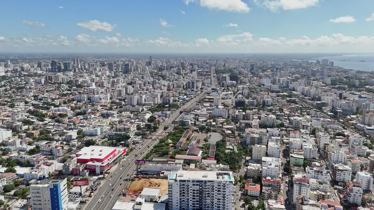 Luftfoto fra høj vinkel af 27 de Febrero Avenue i Santo Domingo, Den Dominikanske Republik, med udsigt over bybilledet og kystlinjen.