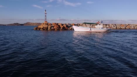 Kleines-Boot-Fährt-Vor-Leuchtturm-Vorbei