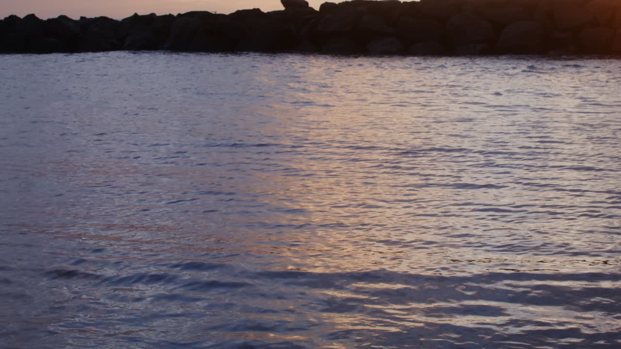 바위와 함께 물 위에 해가 지는