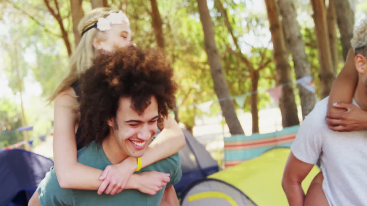Couples in piggyback ride having fun at music festival 4k