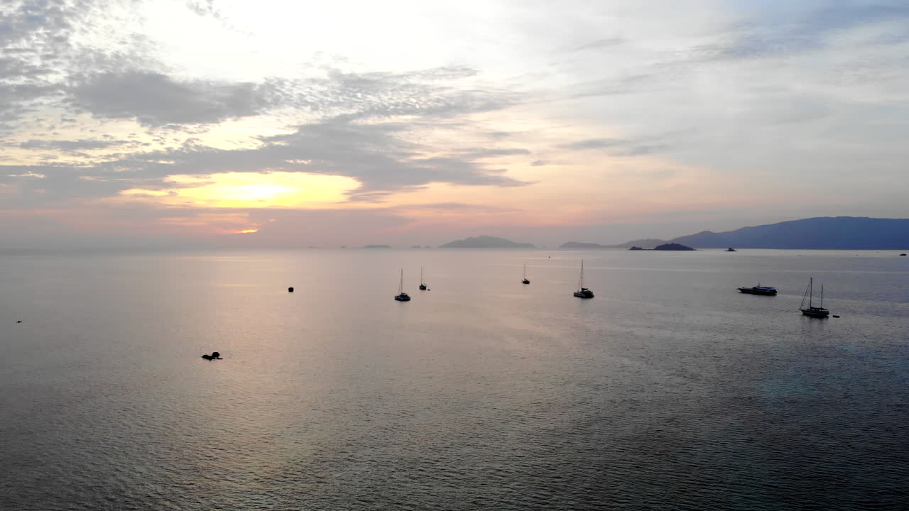 구름과 산 위에 맑은 물, 보트, 선셋이 있는 바다의 드론 영상