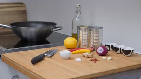 Male-picks-up-knife-and-starts-cooking,-Static-camera