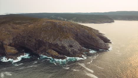 gold and orange light reflected on the surface of the sea near rugged seaside cliffs