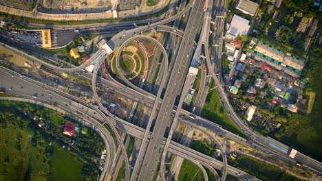 aerial view of highway road interchange with busy urban traffic speeding on road