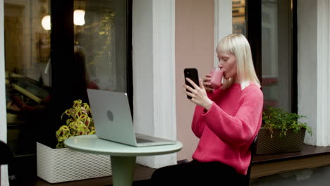 mujer rubia videollamada en la terraza.