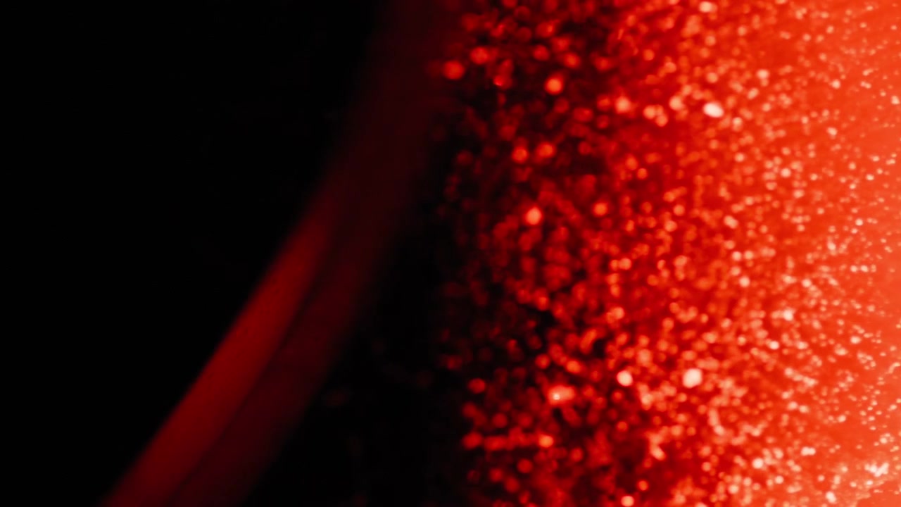 Perdite di Luce Rossa Astratta da un Oggetto di Vetro su Sfondo Nero