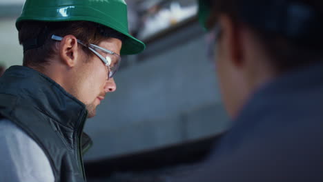 Engineer-working-at-livestock-facility-closeup.-Focused-workers-wearing-uniform.