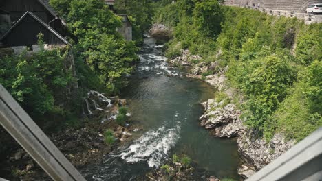 River-flowing-through-lush-green-forest-and-old-stone-buildings-in-Rastoke,-Croatia