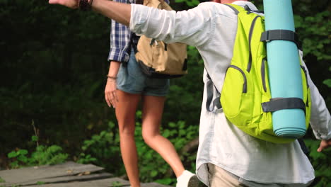 hikers on a wooden bridge in the forest