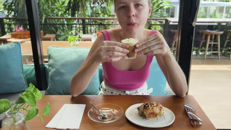 mujer disfrutando de café y pasteles en un café