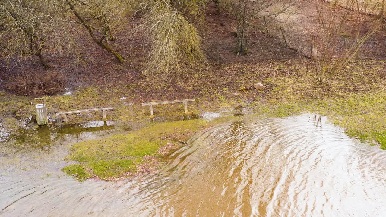 agua de inundación de manantial que fluye a los bancos de un parque