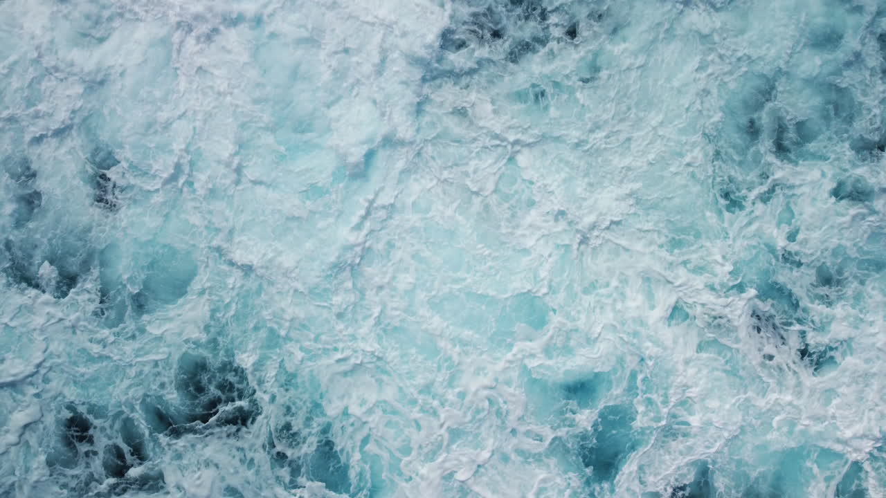 Aerea: inquadratura dall'alto di onde potenti che si infrangono sulla costa rocciosa