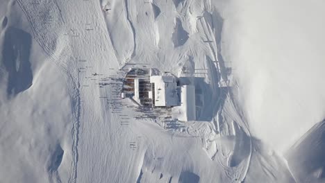 Mountain-huts,-Birds-eye-view-Drone-view-of-the-snow-capped-mountains,-ski-resort-in-Dolomite-Alps-with-snow-in-Madonna-di-Campiglio,-Val-Rendena,-Italian-Alps,-Italy