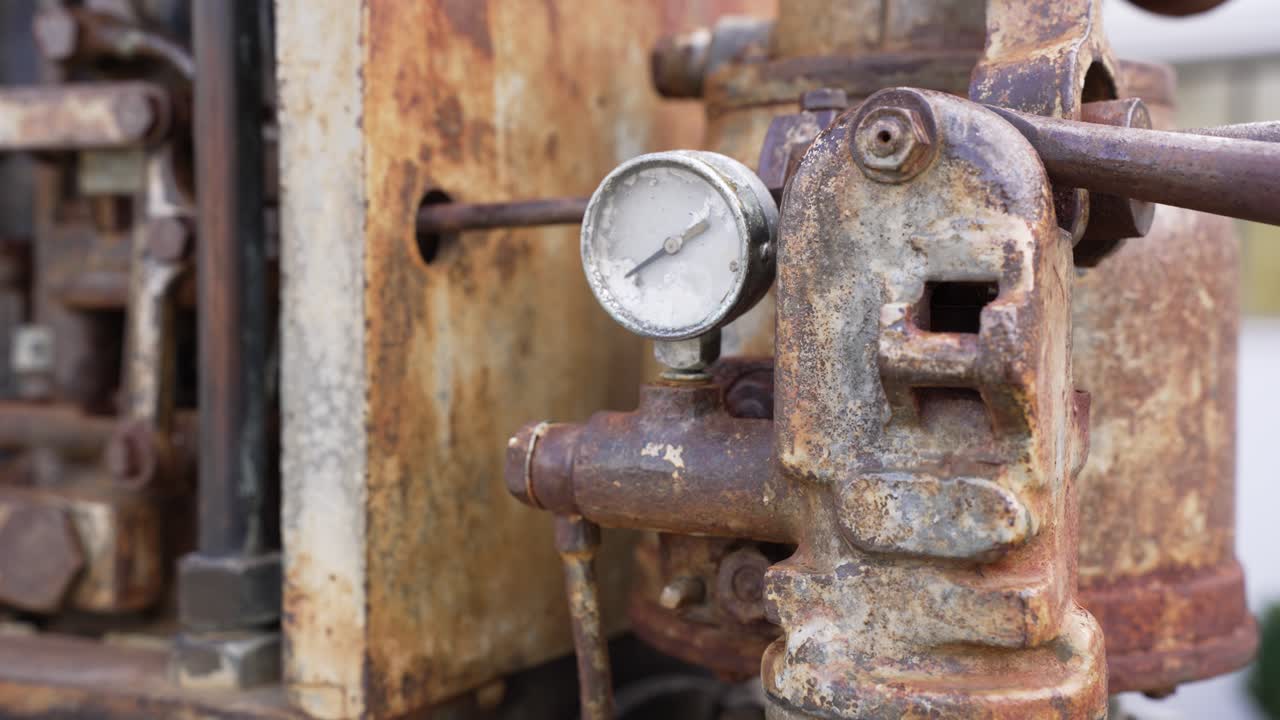 Motore industriale vintage che mostra manometro e corrosione del metallo