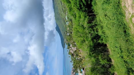 vertical scenic pan of sofitel hotel with overwater villa bungalows and crystal clear turquoise ocean water on tropical moorea island in french polynesia, south pacific