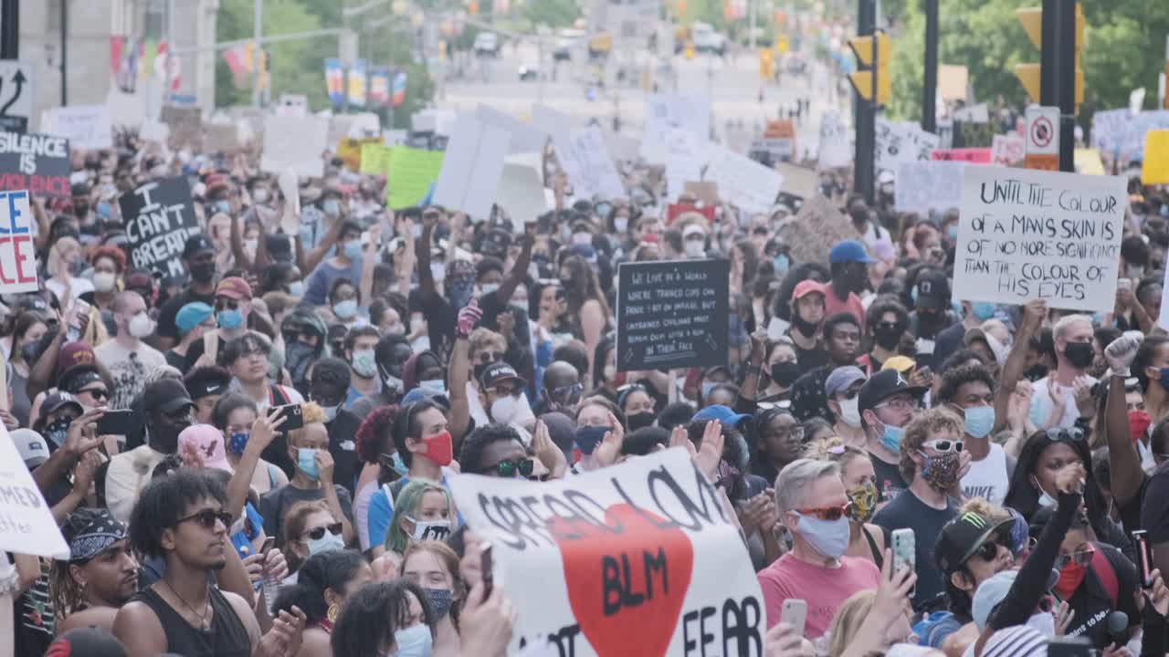 Handheld footage of a mass of protesters out front City Hall in Ottawa, Canada