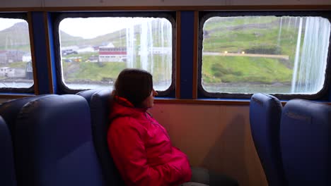 female tourist enjoys view on faroe islands from boat, water-bus