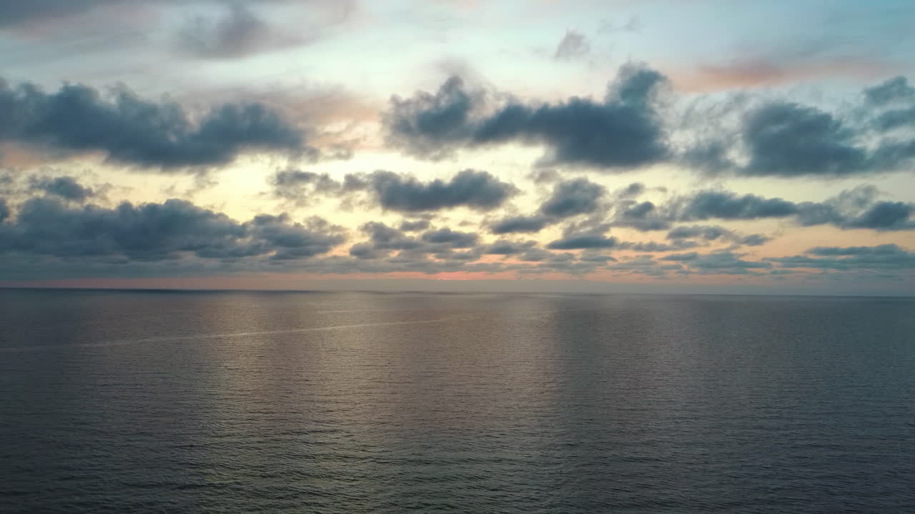 dron volando hacia atrás sobre el mar después del atardecer