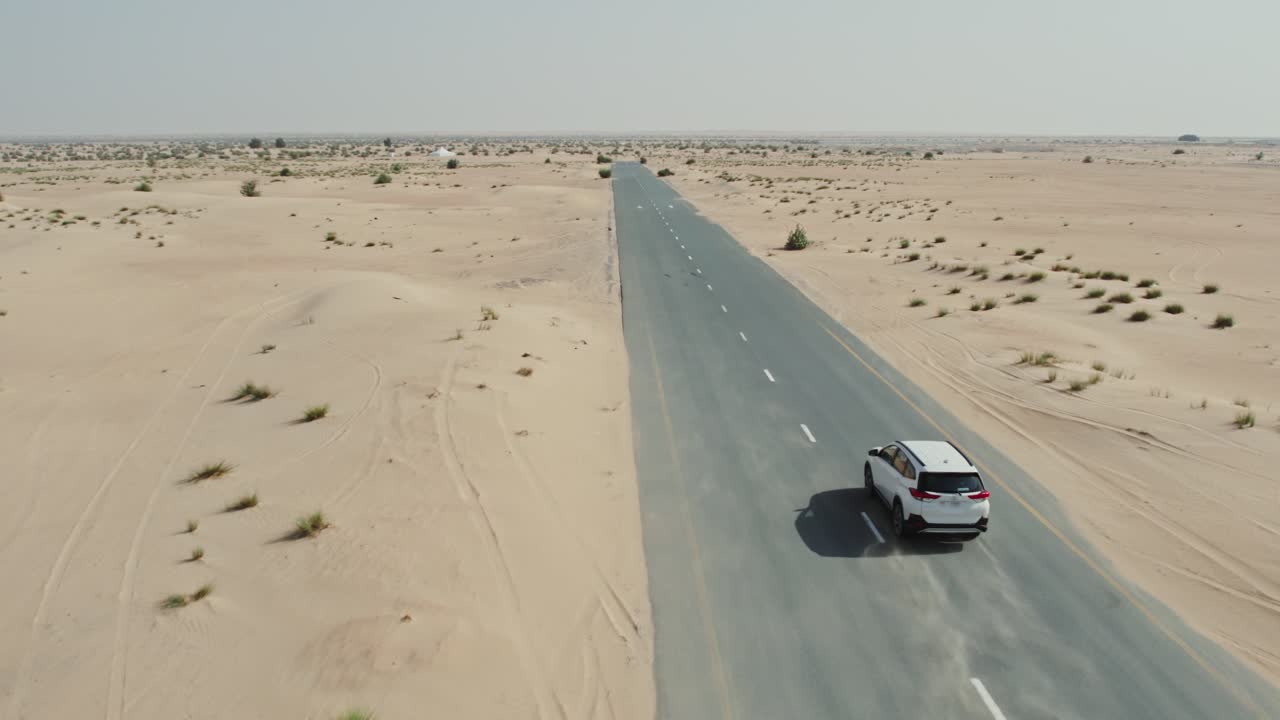 coche blanco conduciendo en una carretera del desierto
