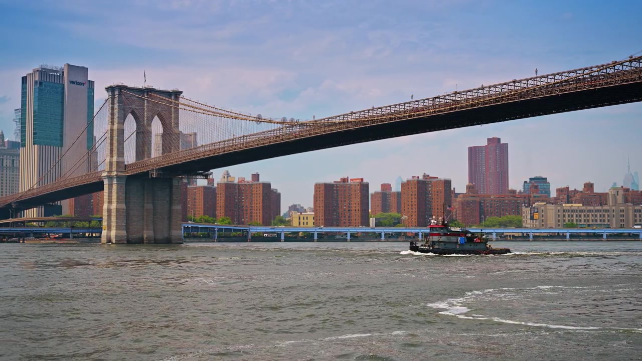 New York, USA, 11 maggio 2026: Rimorchiatore che naviga sull'East River sotto il Ponte di Brooklyn a New York City.