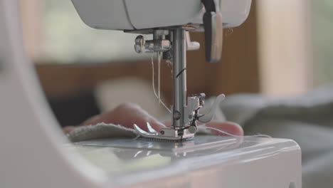 costurera bajando el pie presor de una máquina de coser - toma de primer plano