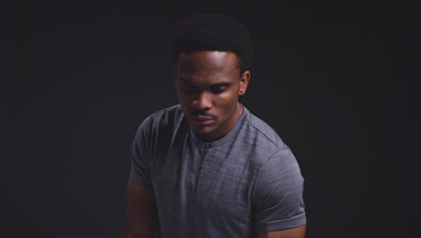 Studio-Portrait-Of-Male-Athlete-Sport-Training-Or-Exercising-In-Gym-Folding-Arms-Against-Black-Background-1