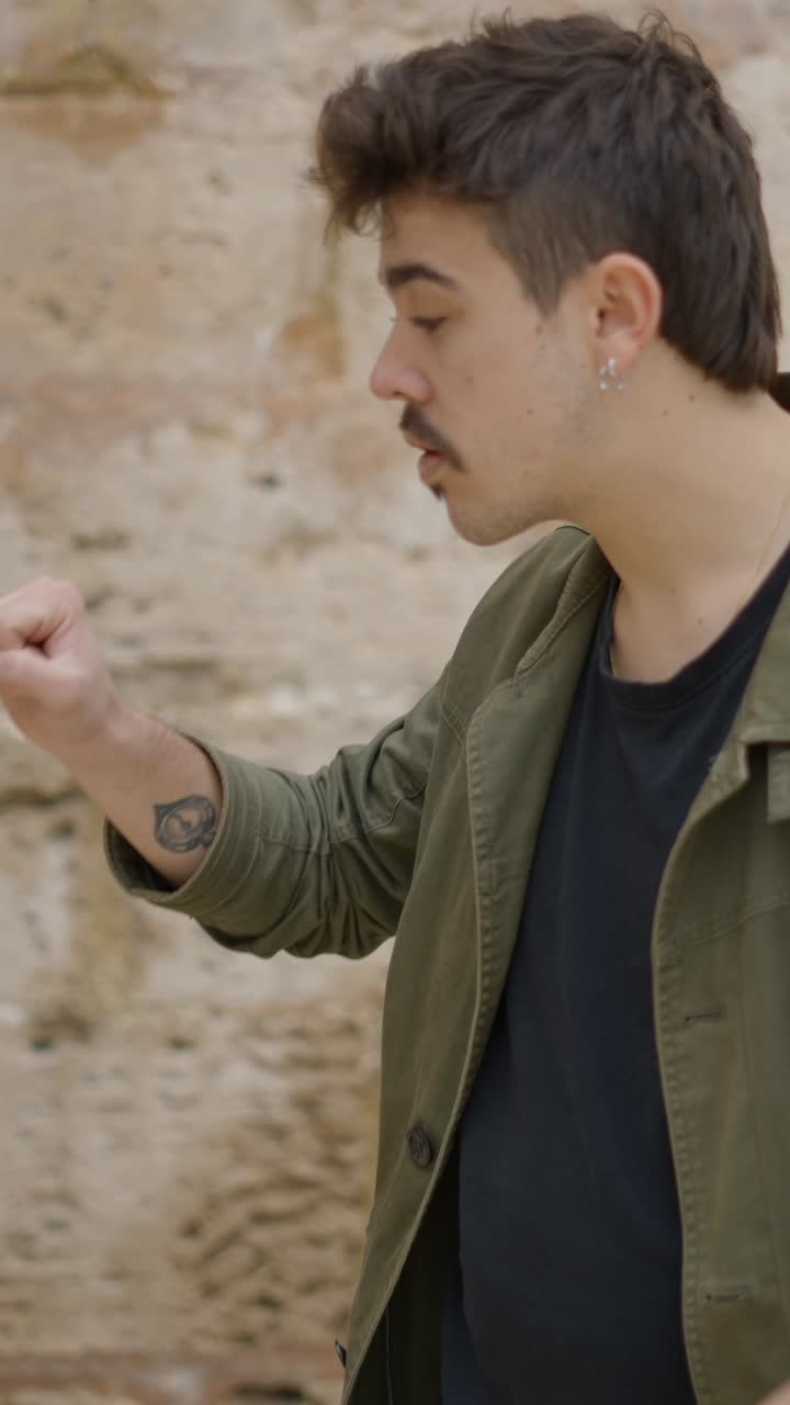 Uomo che mostra un oggetto con un pugno chiuso