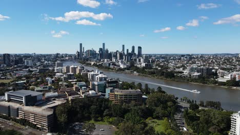 un ferry de la ciudad viaja a lo largo del río brisbane con el imponente horizonte de la ciudad en la distancia