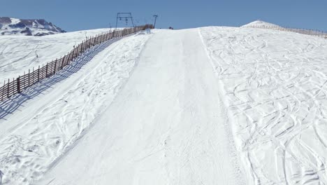 Aerial-shot-overhead-a-single-skier-down-a-ski-slope-in-the-Farellones,-Chile