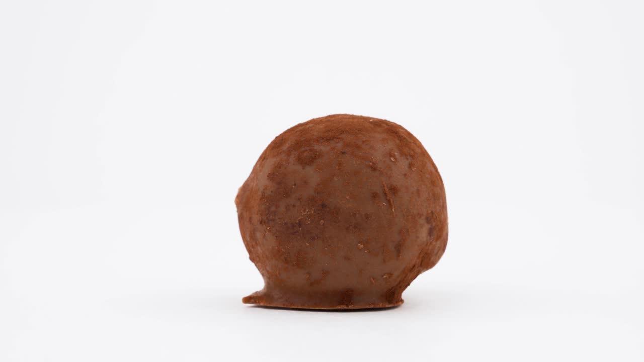 우유 초콜릿 손으로 만든 디저트, 트루플 사탕, 회전 테이블에서 회전, 색 배경에서 고립, 클로즈업, 매크로.