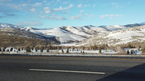 driving side view of snow capped mountains in utah