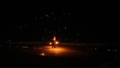 performer displays fire skills on a beach