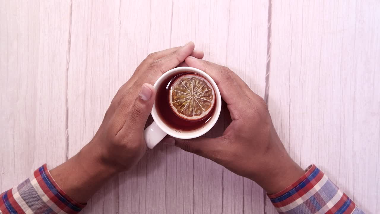 손은 레몬으로 차 한 잔을 들고 있다