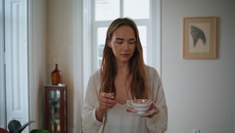 chica relajada caminando por la mañana de cerca. mujer tranquila bebiendo café cruzando a casa