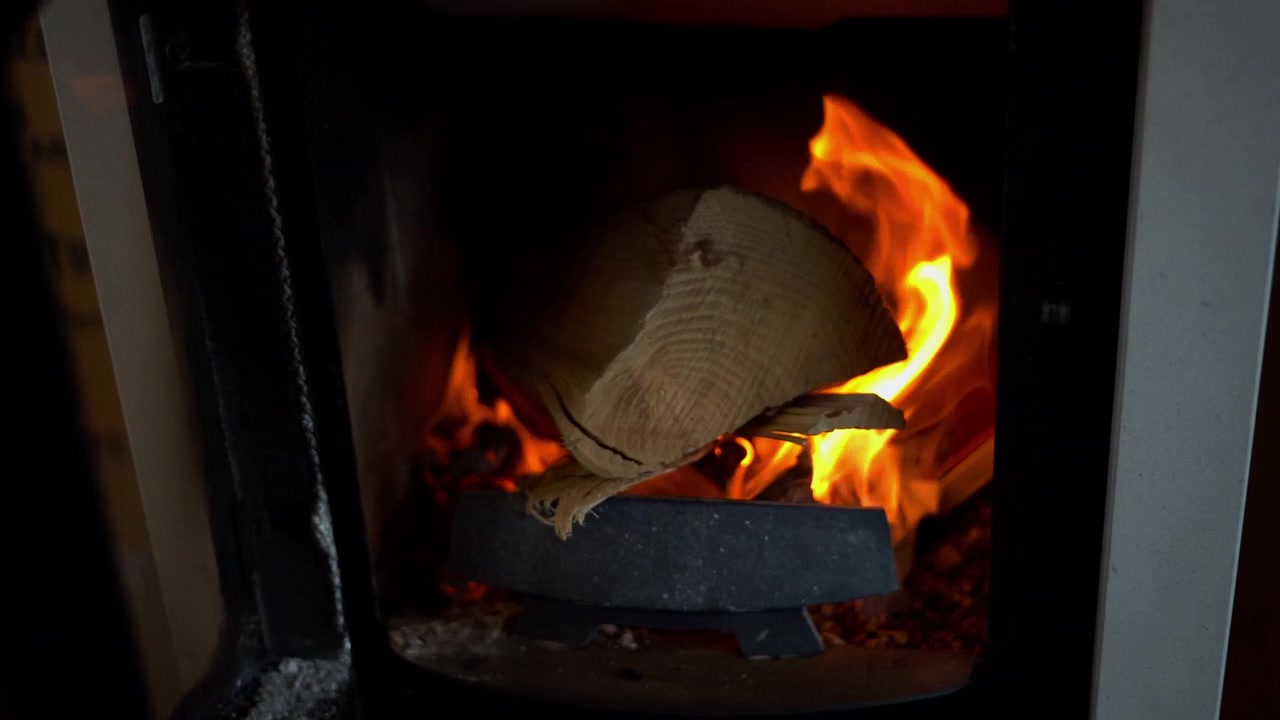 Brændeovn med gnister og flammer i en hyggelig, varm pejs indendørs