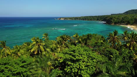 impresionante vuelo bajo sobre la playa de la presiosa en cabrera con una hermosa vista entre las palmeras y el agua azul turquesa en un día maravilloso