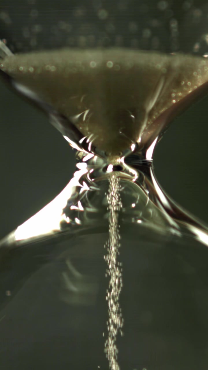 Close-up of Sand Flowing Through a Glass Hourglass