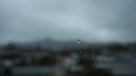 Cierre-De-Gotas-De-Lluvia-En-Una-Ventana-Con-Automóviles-Fuera-De-Foco-En-El-Fondo