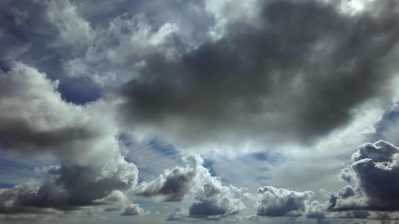 An aerial cloudscape recorded from inside a jet cockpit while flying at supersonic speed under cottony clouds, high angle view, with a radiant sun piercing the clouds. 4K