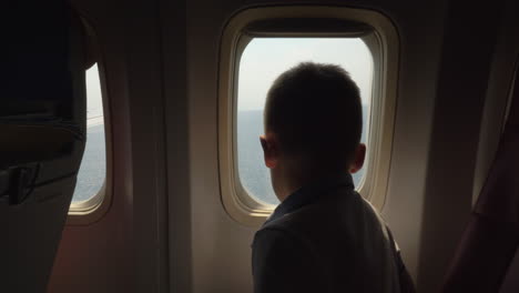 niño mirando a través del iluminador cuando el avión va a aterrizar