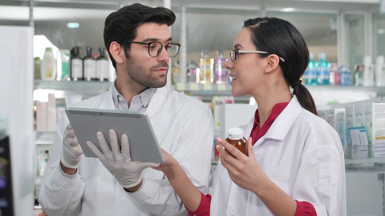 farmacéutico masculino y femenino que utiliza una tableta digital para comprobar el stock